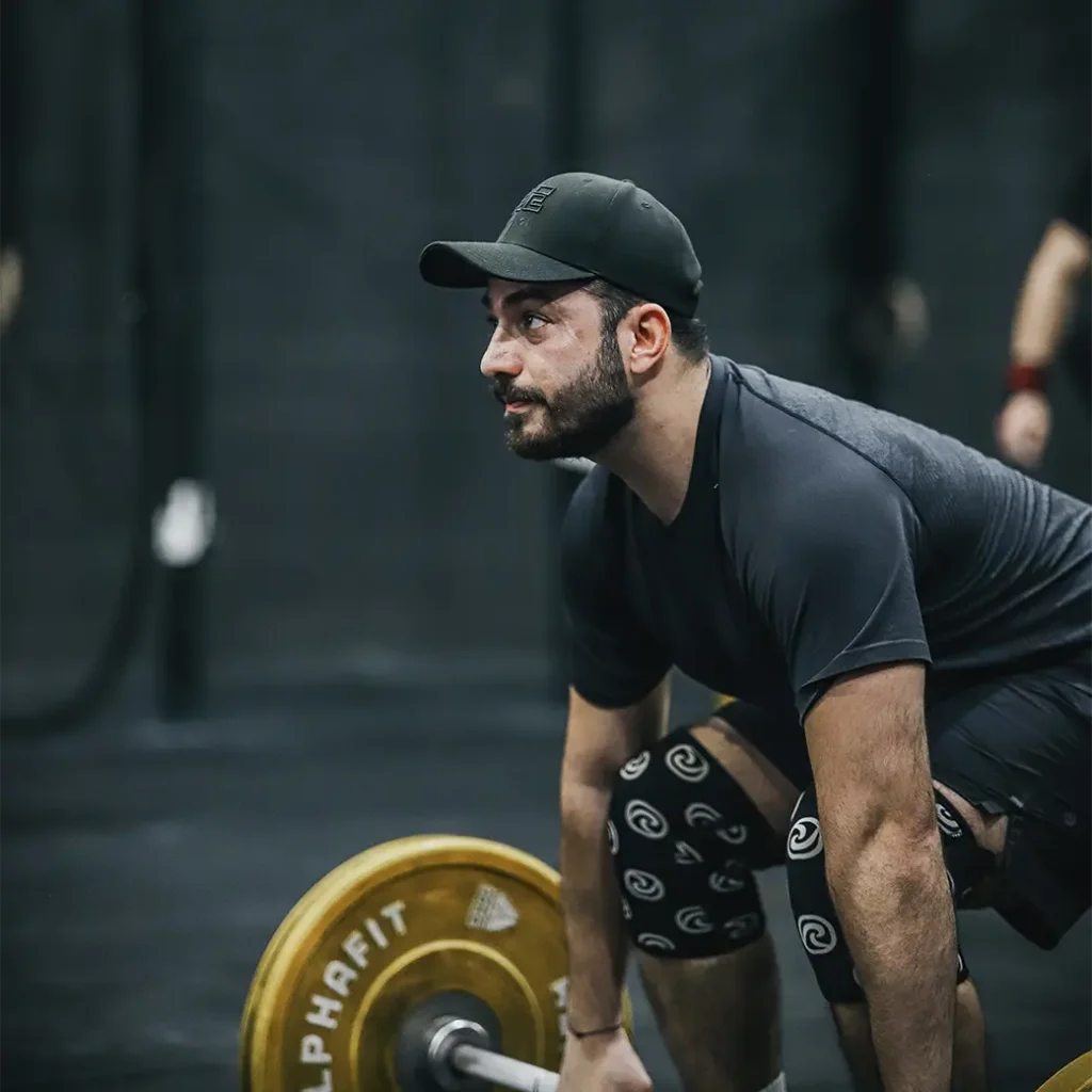 a man leaning forward preparing to lift a barbell