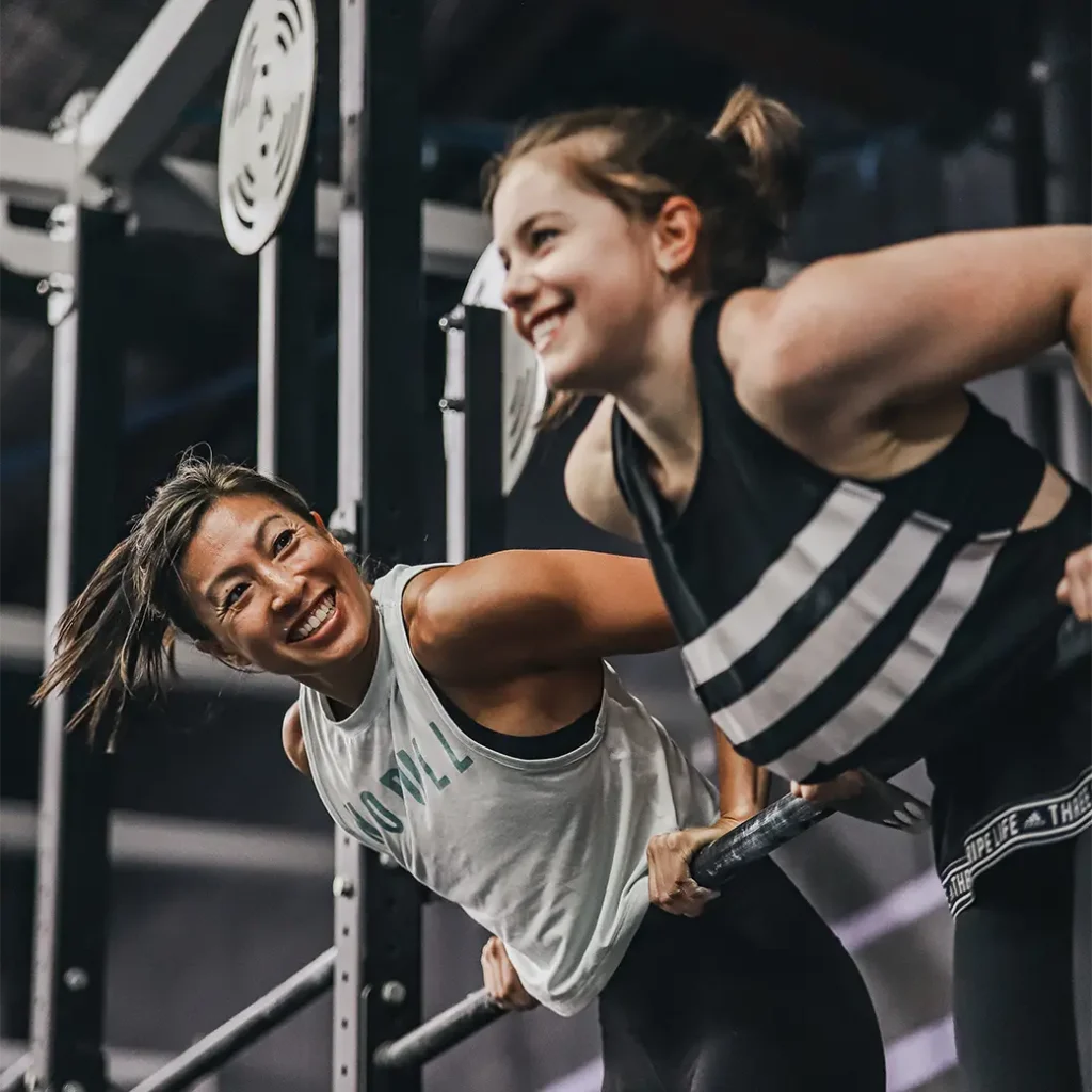 a photo of two happy girls on a bar pull ups