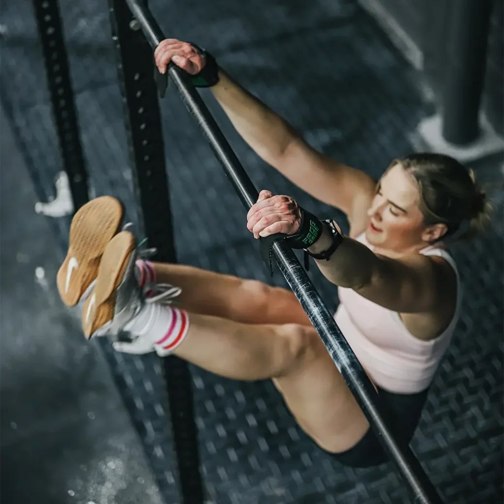 a photo of a girl with her feet raised higher than the bar she is holding
