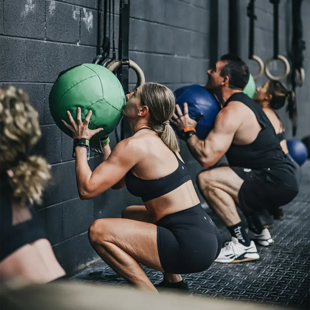 a group of people doing a slam ball exercise