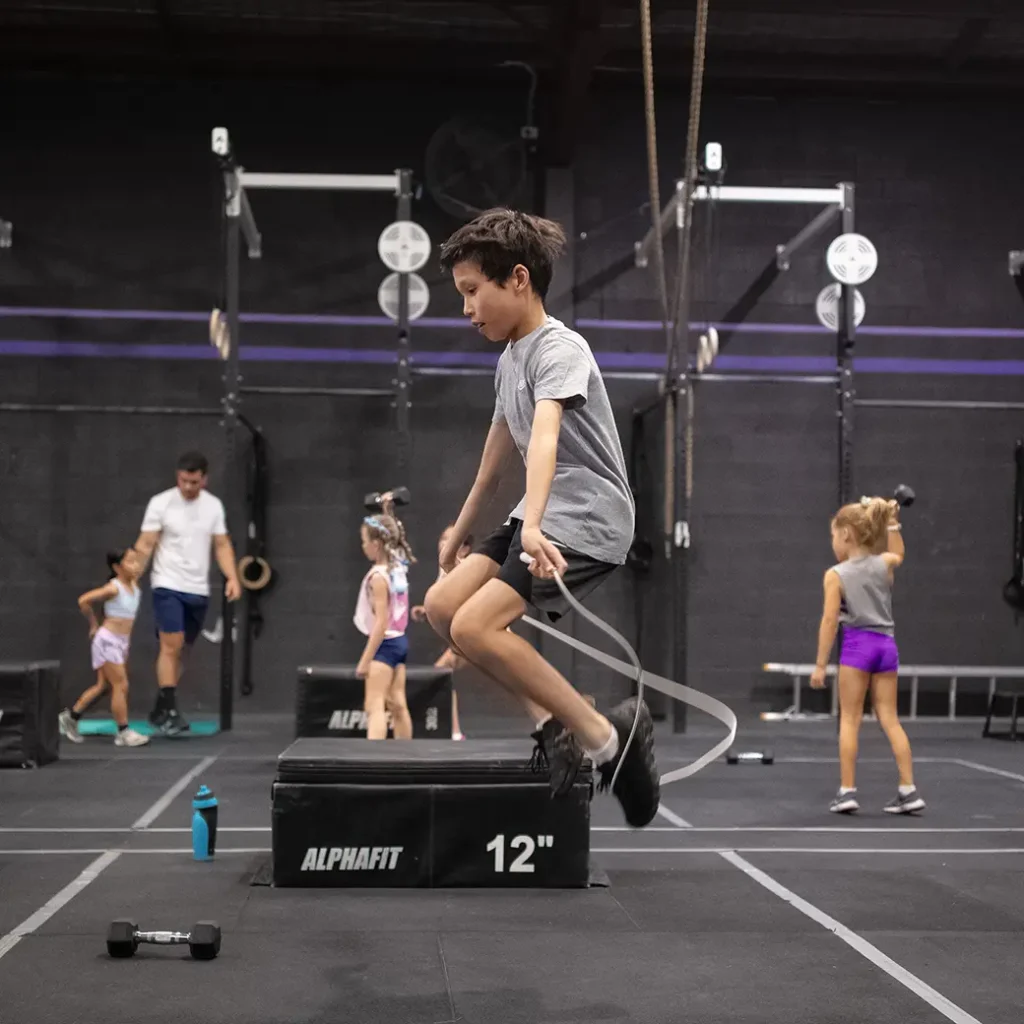 a kid doing a jumping rope exercise inside a gym