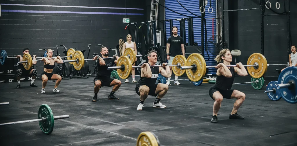 A group of men and women lifting weights simultaneously.