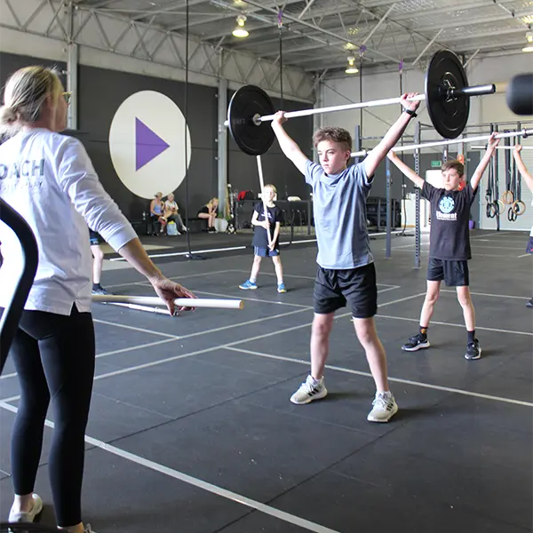 a group of kids doing a weight lifting exercise